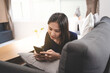 © mojo_cp - asian woman using mobile phone at home Communication and coziness concept