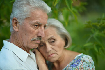 Portrait of sad senior couple in the park