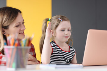 Woman and mother sitting at table and communicating through laptop screen