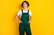 Photo of pretty cheerful girl put arms in pockets toothy smile look camera isolated on yellow color background