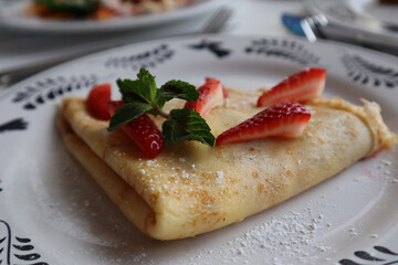 Poster - Closeup of a crepe with strawberry, mint garnish at a luxury resort in  Mexico