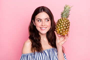 Sticker - Photo of charming cute young woman dressed striped outfit biting lip holding fruit looking empty space isolated pink color background