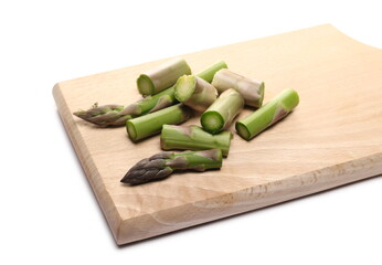 Wall Mural - Fresh asparagus sprout slices on wooden chopping board isolated on white background