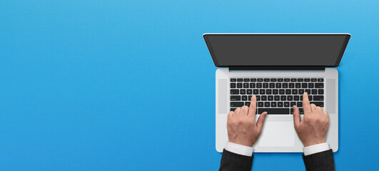 Businessman hands working laptop with copy space on blue background