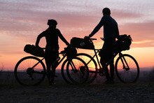 Bike Packing Cyclists Leaning On Their Packed Bikes During Springtime Sunset