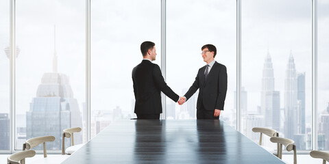 Sticker - Successful business partnership and deal concept with smiling businessmen handshaking hands in conference room on high floor of city skyscraper