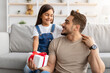 © Prostock-studio - Daughter celebrating father's day, greeting excited dad with present