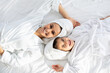 © Prostock-studio - Happy mother and daughter in bathrobes laying on bed