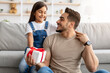© Prostock-studio - Girl celebrating father's day, greeting excited dad with present
