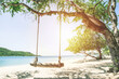 Swing tied under tree with beach and seaside fresh sky background. Holiday and Vacation concept. Chilling and Relax concept. Fresh Holiday. Alone concept