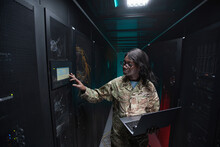 Side View Portrait Of Young African-American Woman Wearing Military Uniform Using Laptop While Standing In Server Room, Copy Space