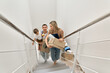 © insta_photos - Happy family couple new home owners real estate buyers or renters with toddler kid child son carrying boxes going up stairs on moving day arriving into new apartment. Relocation, mortgage, removals.
