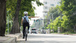 © torwaiphoto - Workers women go cycling in the city to work at rush hour.She gave her arm to the traffic signal.