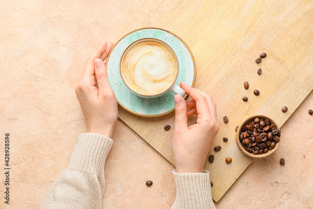 Woman drinking hot cappuccino coffee, top view