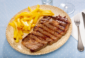 Tasty homemade grilled beef steak served with fried potato .