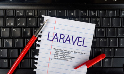 laravel php framework programming language. word laravel on paper and laptop