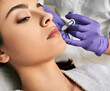 © Peakstock - Lip augmentation procedure. Filler injection for beautiful woman lip augmentation with hyaluronic, side view