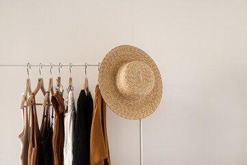 women's fashion bright pastel clothes on clothing rack on white background. minimalist fashion blog 