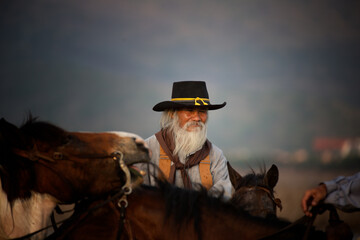 cowboy on horseback against a beautiful sunset, cowboy and horse at first light,mountain, river and lifestyle with natural light background..