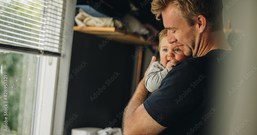 Father consoling his baby at home - obrazy, fototapety, plakaty 