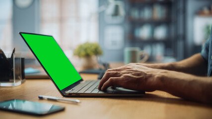 Aufkleber - Close Up on Hands of a Male Specialist Working on Laptop Computer with Green Screen Mock Up Display at Home Living Room. Freelance Man Chatting to Clients Over the Internet on Social Networks.