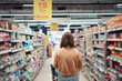 © oatawa - Female customer shopping at supermarket with trolley.