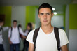 © liderina - Portrait of male student.  Male Students standing in school hallway.