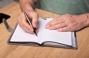 Poster - Male hands taking notes, writing plans in notebook or planner. Planning in schedule diary, close up. Starting from scratch concept.