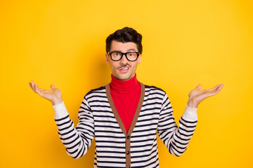 Wall Mural - Photo of young man shrug shoulders hold hands unhappy dilemma doubt questioned no answer isolated over yellow color background