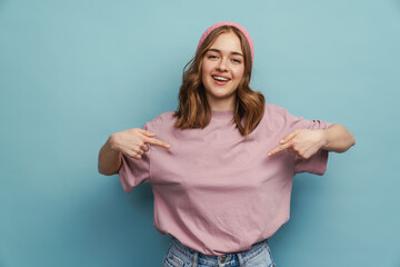 Wall Mural - Young happy woman smiling and pointing fingers at herself