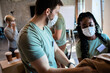 © Zoran Zeremski - Group of volunteers with face mask working in community charity donation center.