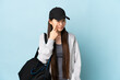 © luismolinero - Young sport Chinese  woman with sport bag over isolated blue background showing something