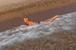 Tanned short-haired nine-year-old boy swims by the sea and plays with the waves in the summer