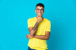 © luismolinero - Young Brazilian man isolated on blue background happy and smiling