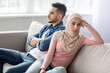 © Prostock-studio - Sad young woman in hijab sitting by her sad husband