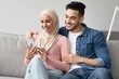 © Prostock-studio - Joyful muslim couple watching photos on mobile phone together