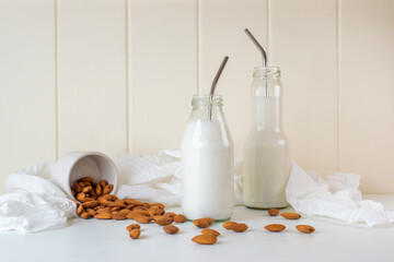 Home made two almond milk in bottles with almond in bowl. 