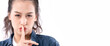 © whyframeshot - portrait of asian female woman , holding a hand near face, finger on the lips, against a plain studio background.silent gesture signage female white background
