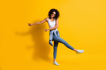 Wall Mural - Full body photo of dark skin trendy woman wear casual outfit jacket on waist sunglass dance isolated on yellow color background