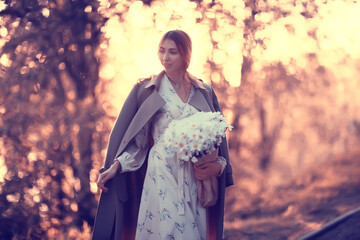 Wall Mural - girl holding a bouquet of flowers a walk in the park / romantic young beautiful cute model, love fee