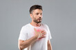 © Prostock-studio - Man with chest pain touching inflammated zone, grey background