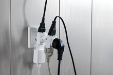 Multiple Plugs In Wall Electrical Outlet Is Dangerous Overload, Close-up