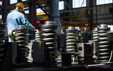 Kazakhstan, Nur-sultan locomotive-building plant. Close-up of damper spring. Worker on background, blurred.