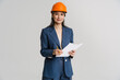 © Drobot Dean - Asian smiling woman wearing helmet posing with clipboard and pencil