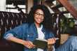 © InsideCreativeHouse - Smart african-american young woman reading book at home. People and leisure concept. Weekend Pastime.