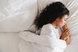 © InsideCreativeHouse - Beautiful young african girl sleeping in her bed. Serene calm african american woman sleeping in comfortable bed lying on soft pillow orthopedic mattress, peaceful young black lady resting.
