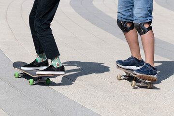 legs of two teenager on a skateboard