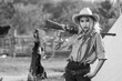 Cowgirl wears a rifle in hand to display a vintage defensive weapon.