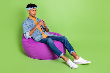 Sticker - Photo of guy sit beanbag hold fingers wear headband denim jeans shirt footwear isolated green color background