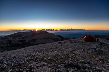 Pelino bivouac on the top of Monte Amaro at sunrise. Trekking in the Majella national park, the second highest peak of the Apennines. Maiella mountain massif, Abruzzo, L'Aquila.